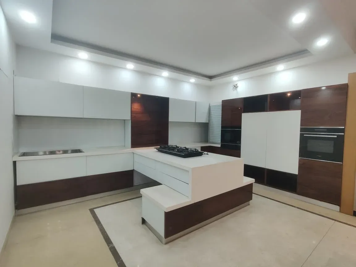 Modular island kitchen with white and walnut cabinets and a two-level island counter